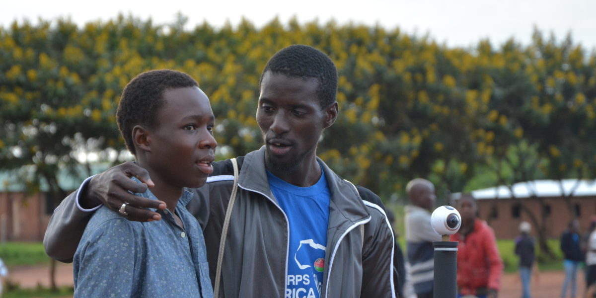 Dos refugiados se toman un descanso durante un partido de baloncesto en el campamento de refugiados de Dzaleka. (Servicio Jesuita a Refugiados)