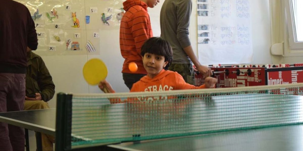 A young boy plays ping pong in a recreation centre. (Jesuit Refugee Service)
